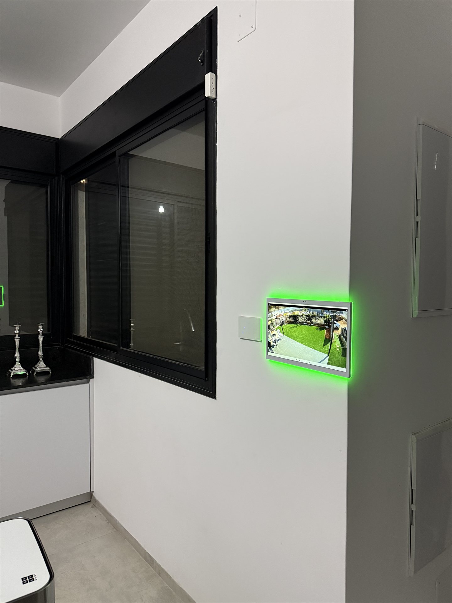 מסך שקוע בקיר עם תאורה ירוקה לצפייה במצלמות אבטחה
