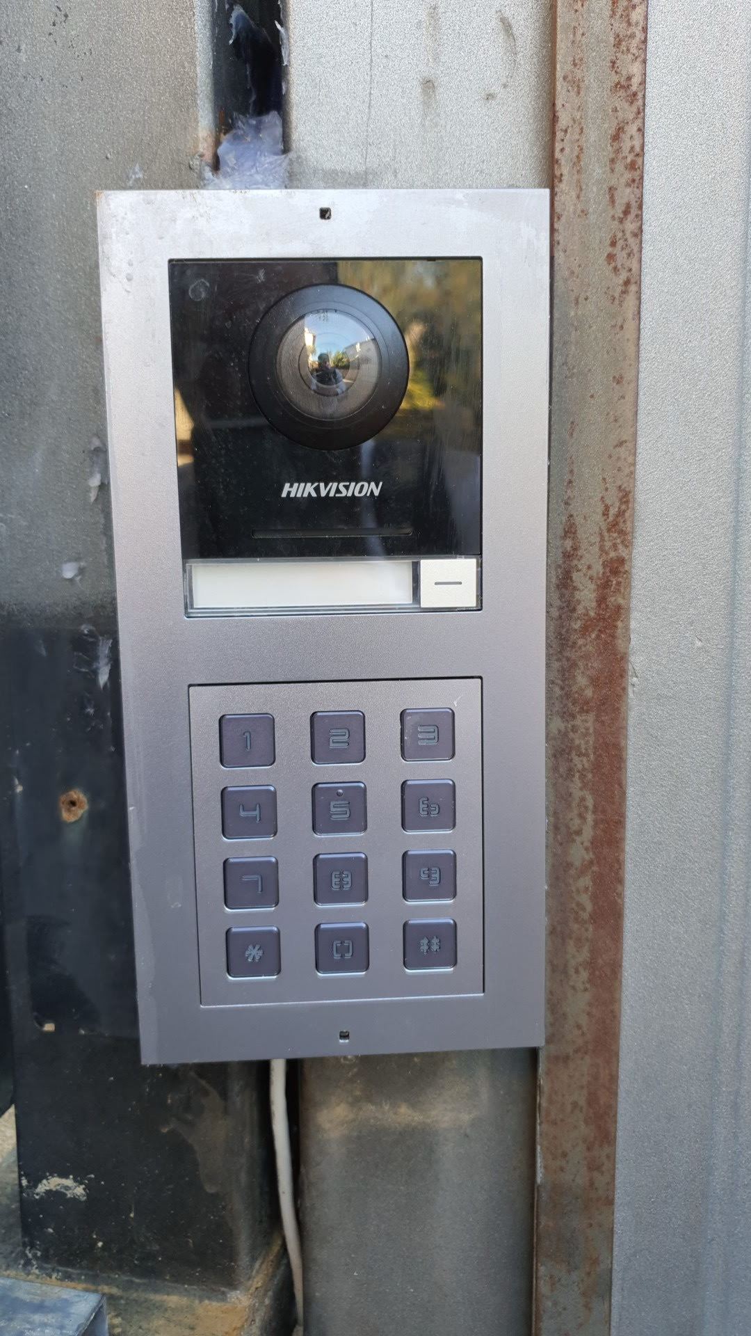 אינטרקום Hikvision עם מצלמה וקודן מותקן על שער מתכת